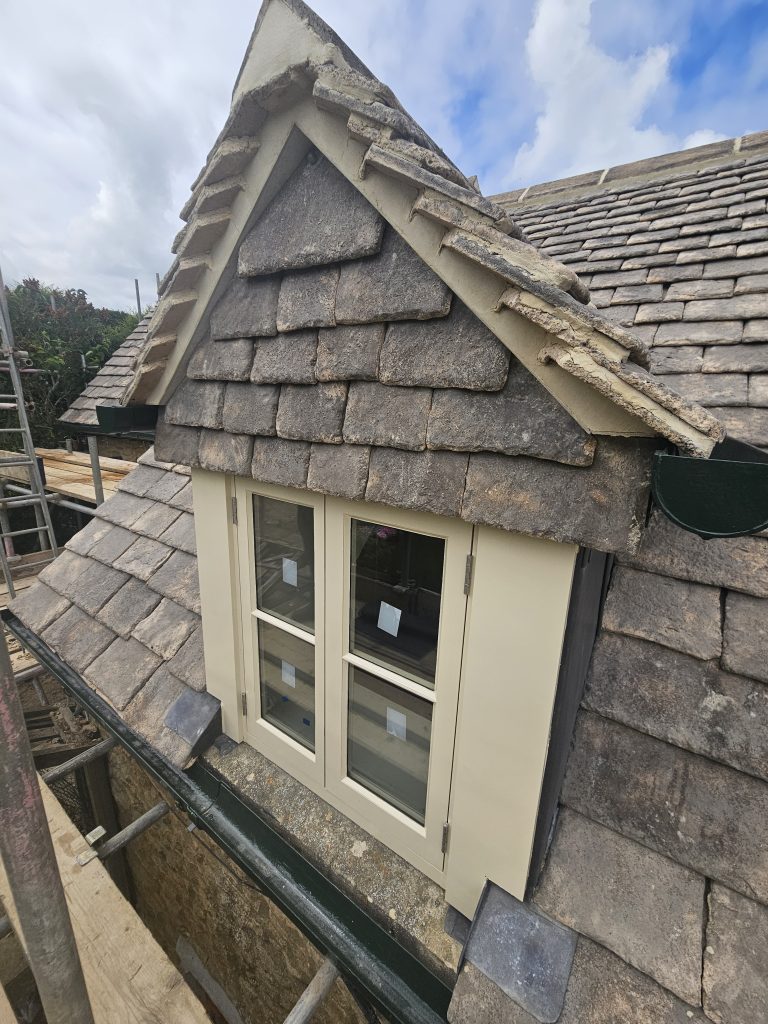 Stone-slate dormer with new cream timber casement windows