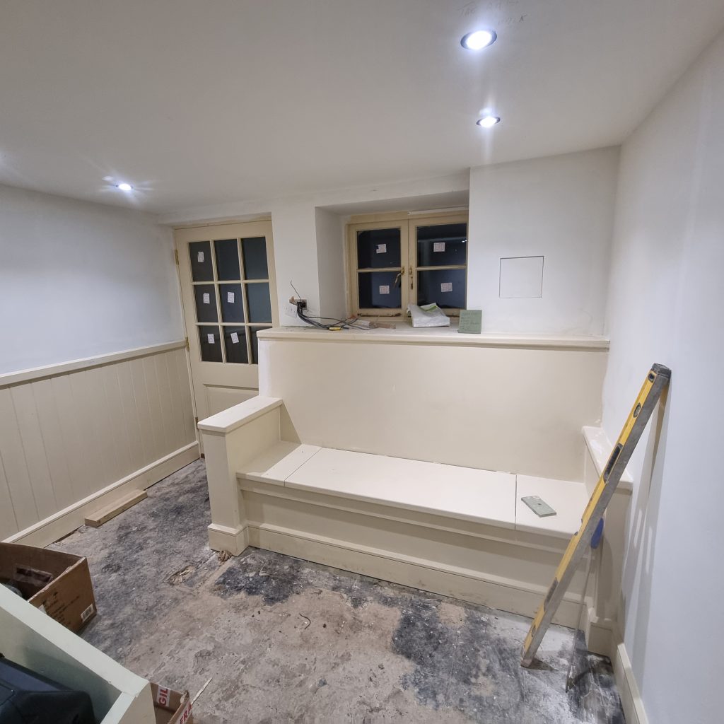 Bespoke built-in seating and wall panelling during a room renovation