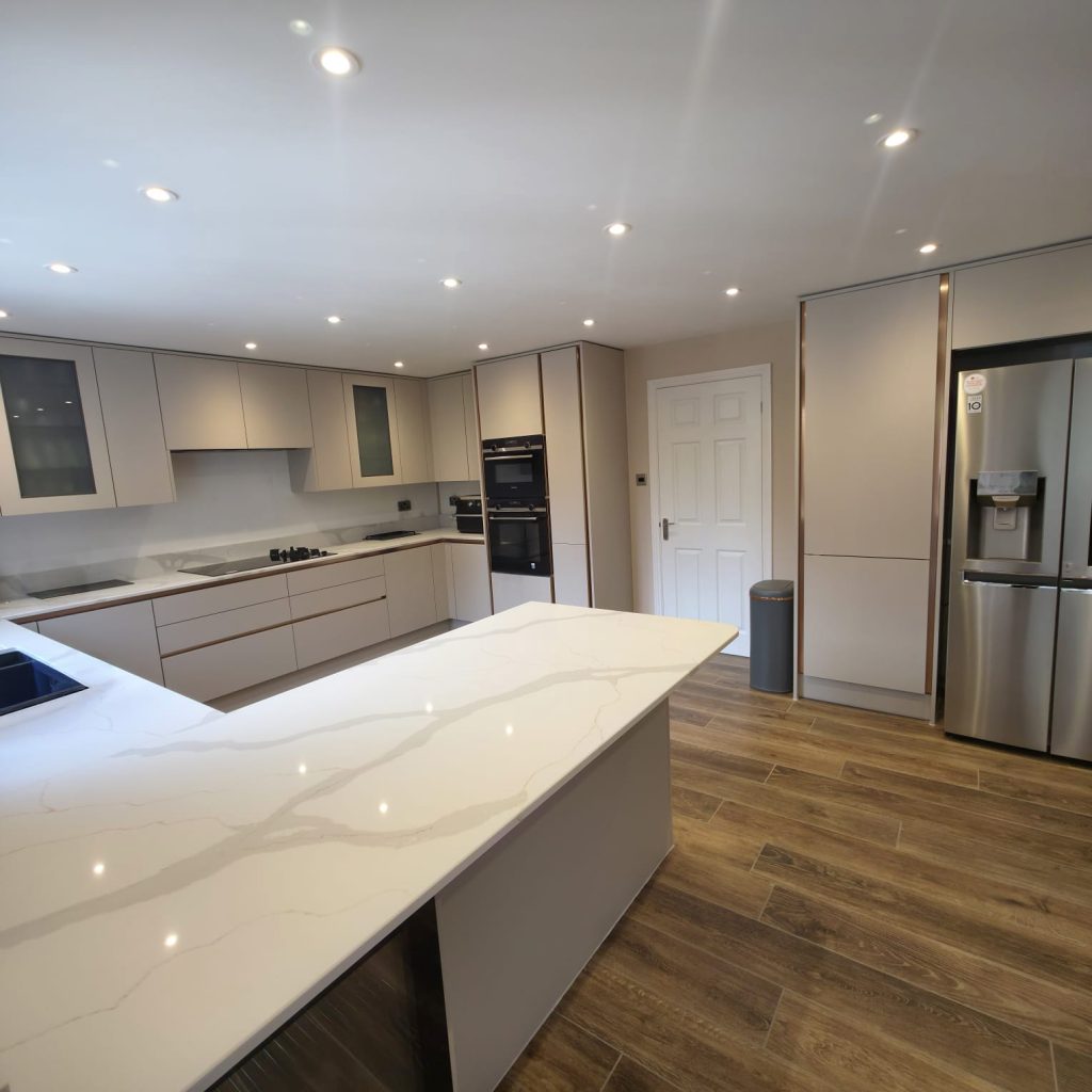 Modern kitchen with a white marble-effect island, handleless units and integrated appliances